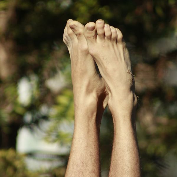 Person balancing in a tree yoga pose against a clean background.